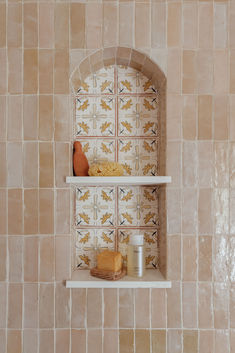 two shelves with different items on them against a tiled wall in a room that looks like it could be used as a spa