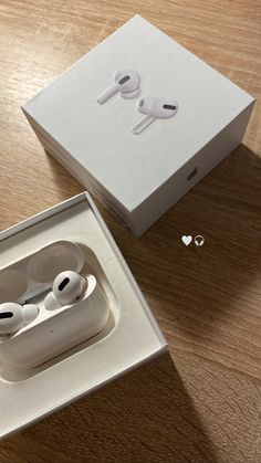 an apple airpods sitting in a box on top of a wooden table