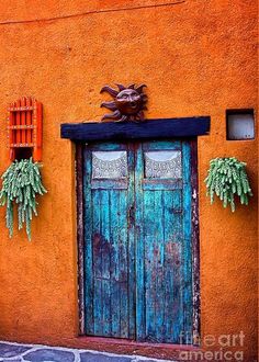 an orange building with two wooden doors and windows