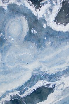 an abstract painting with blue and white paint on it's surface, as well as water