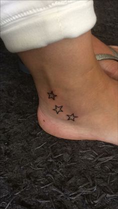 a woman's foot with three small stars on the bottom of her left ankle