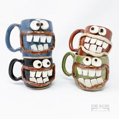 two ceramic mugs with eyes and mouths on them