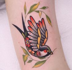 a bird with colorful wings and flowers on it's back leg is flying through the air