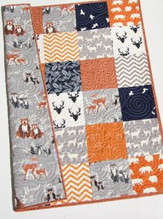 an orange and gray quilt with animals on it