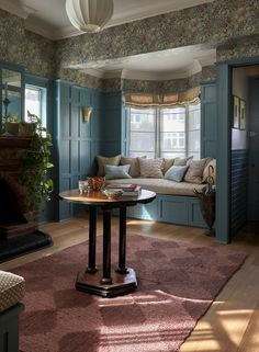 a living room filled with furniture and a fire place under a window next to a couch