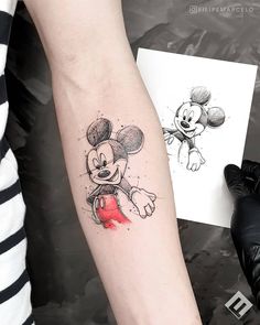 a person with a mickey mouse tattoo on their arm