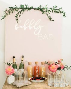 a table topped with bottles and glasses next to a sign that says, baby bar