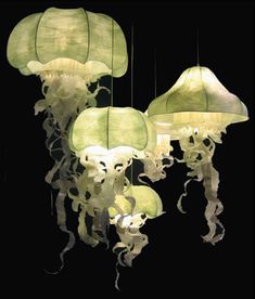 some very pretty lights that are hanging in the dark room with jellyfish on them