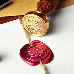 a waxed seal sitting on top of a piece of paper next to a rubber stamp