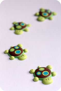 some little turtle buttons on a white surface