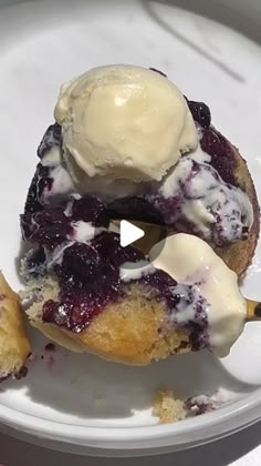 a white plate topped with blueberry donuts covered in ice cream