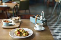 a table topped with plates of food next to cups and saucers on top of it