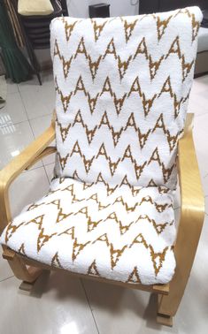 a white and brown chair sitting on top of a tiled floor