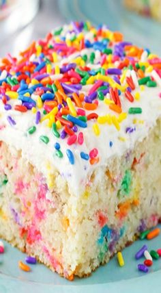 a piece of cake with white frosting and sprinkles