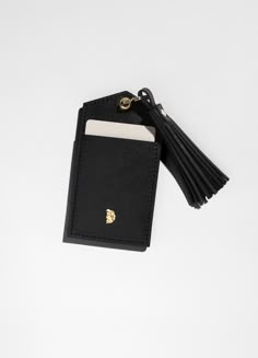 a black card case with a tassel hanging from it's side on a white surface