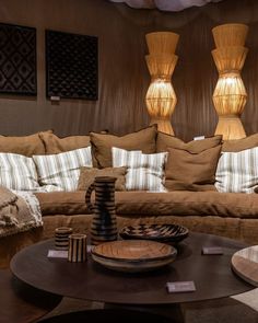 a living room filled with lots of furniture and pillows on top of a wooden table