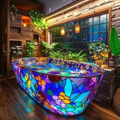 a bathtub made out of stained glass in a room with plants and potted plants