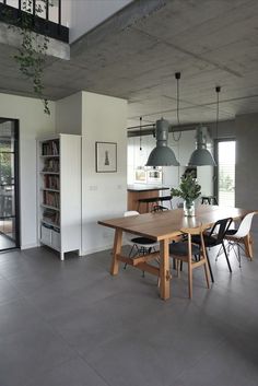 a table and chairs in a room with concrete floors