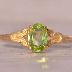 The Hove: Peridot Ring In Yellow Gold With Patterned Shank. This Delicate Ring Centers On An Oval Brilliant-Cut Natural Peridot With A Patterned Shank. The Ring Is Crafted In 14 Karat Yellow Gold And Is Currently A Finger Size 4.25 Yet Can Be Adjusted To Any Finger Size For An Additional Charge On Request. Yellow Peridot Wedding Jewelry, Yellow Peridot Wedding Rings, Peridot Engagement Rings, Green Gemstone Ring, Green Rings, Peridot Ring, Green Gemstones, Delicate Rings, Emerald Ring