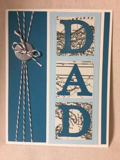 a card with the word dad written in blue and white, tied up to a pair of scissors