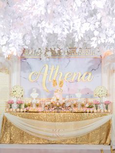 a table topped with cake and flowers under a chandelier filled with white flowers