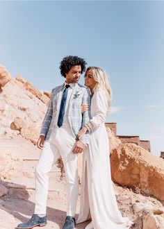 a man and woman standing next to each other in the desert