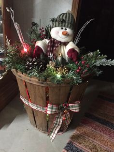 a stuffed snowman sitting in a wooden basket