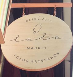 a wooden sign hanging from the side of a building that says, desde - 2013 madrid polos artesano