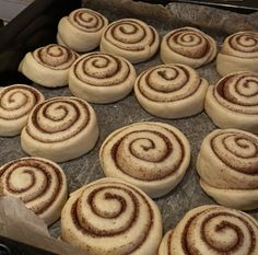 several cinnamon rolls on a baking sheet ready to be baked