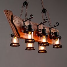 an old fashioned light fixture is hanging from chains and has five lights on each end