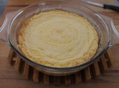 a pie crust in a glass dish on a wooden cutting board