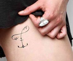 a woman's stomach with an anchor tattoo on her lower side and the words, love