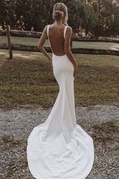 a woman in a white wedding dress looking back