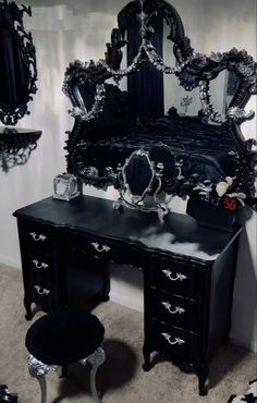 an ornate black vanity with mirror and stool