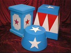 three boxes with stars on them sitting on a red cloth