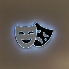 a neon sign with two masks on it