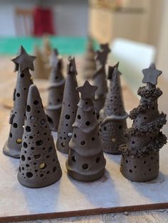 a group of clay christmas trees sitting on top of a wooden table