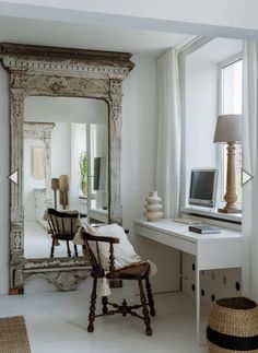 a white desk and chair in a room with a mirror on the wall above it