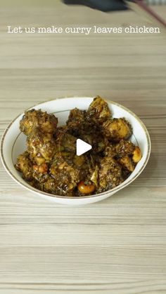 a white bowl filled with food on top of a wooden table