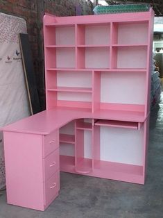 a pink desk with shelves and drawers