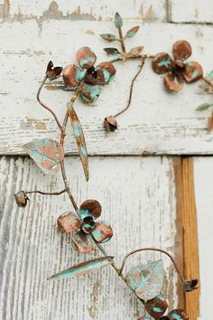 an old door with flowers on it and rusted metal parts hanging off the side