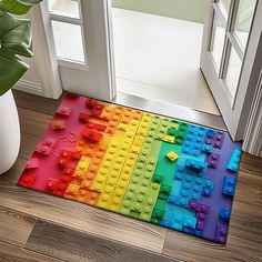 the door mat is made out of legos and has a rainbow pattern on it