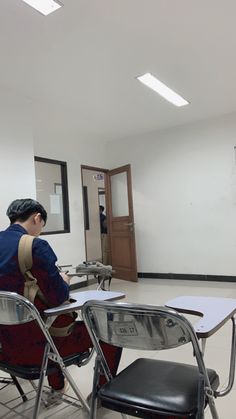 a person sitting at a desk in an empty room