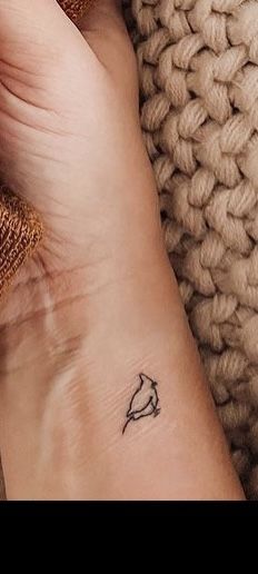 a small bird tattoo on the wrist