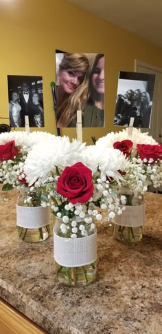 three vases filled with flowers and baby's breath on top of a counter