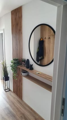 there is a mirror on the wall in this room with wood flooring and white walls