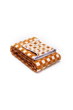 two orange and white checkered blankets folded on top of each other in front of a white background