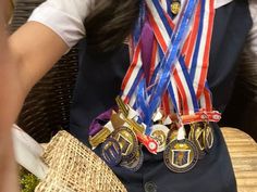 a woman sitting at a table with medals around her neck