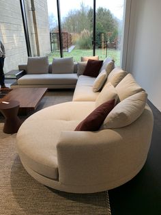 a living room filled with furniture and large windows