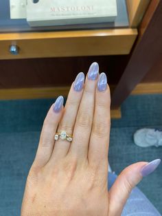 a woman's hand with purple manicures and a diamond ring